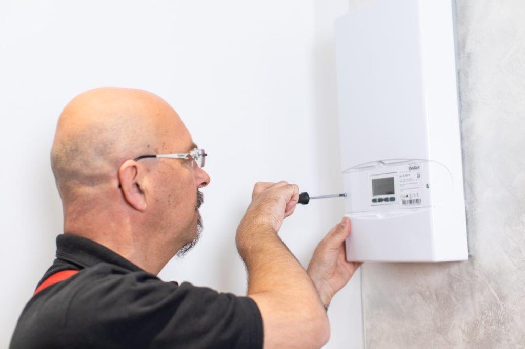Handwerker installiert Heizungskomponenten – Anders Heizung-Sanitär GmbH Bremen